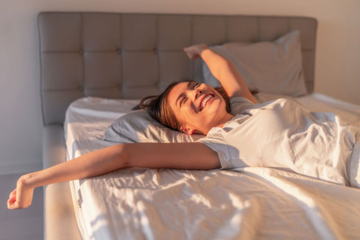 Frau genie&szlig;t Sonne im Bett